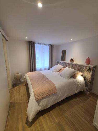 une chambre avec un grand lit et une fenêtre dans l'établissement Maison de bourg bretonne, à Baulon