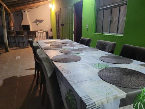 a long table in a room with green walls at Unidades 1 e 2 e 3 Pousada do Sossego Mar e Verde in Itanhaém