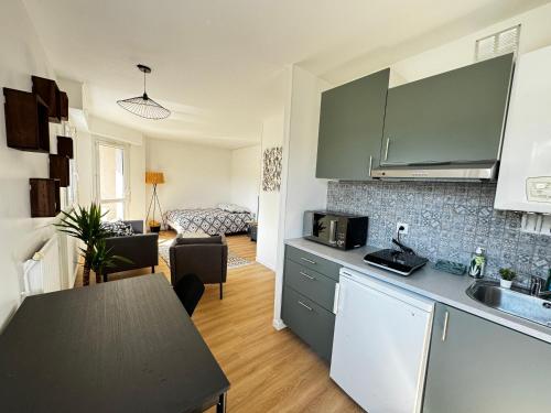 une cuisine avec un comptoir et un salon dans l'établissement Un cocon en plein centre ville, à Osny
