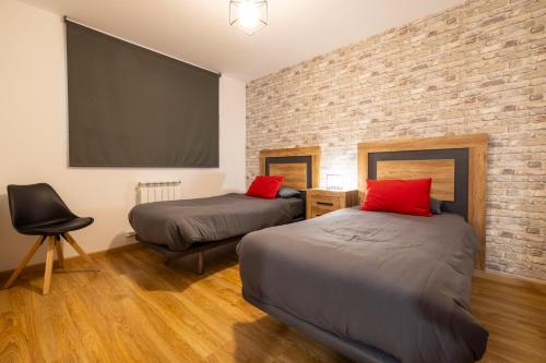 アリンサルにあるIncreibles Vistas Al Valle De Arinsal NY - A Pie De Pistas - Parking Incluido l by BonesVacancesのベッドが2つとレンガの壁がある部屋
