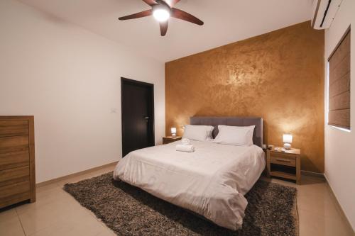 una camera da letto con un letto e un ventilatore a soffitto di Blossom Bliss apartment a Msida