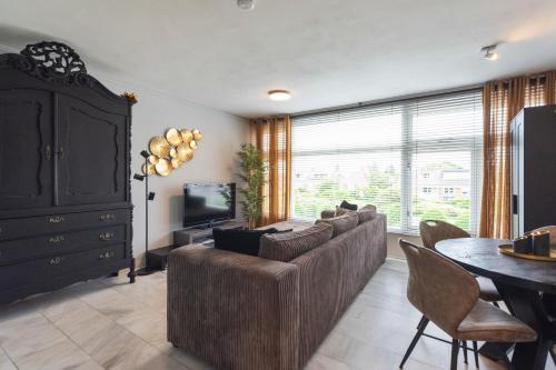 a living room with a couch and a table and a television at De Schelp 58 in Zandvoort