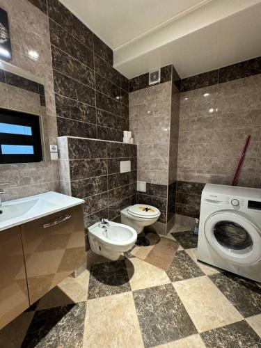 a bathroom with a toilet sink and a washing machine at Style Aparts in Chişinău