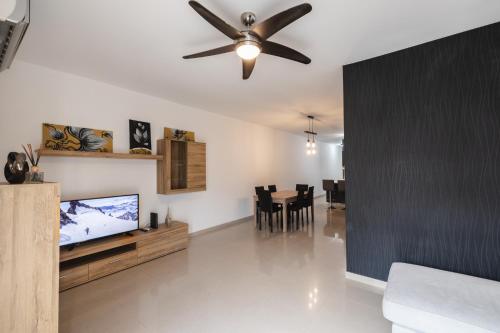 un soggiorno con ventilatore a soffitto e TV di Blossom Bliss apartment a Msida