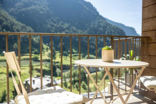 a table and chairs on a balcony with a view of a mountain at Vistas PRECIOSAS Al Valle De Arinsal - 6PAX- A Pie De Pistas & ESQUÍ - Free Parking l by BonesVacances in Arinsal