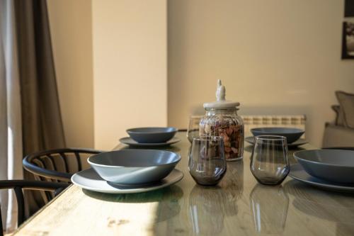 a wooden table with bowls and glasses on it at Vistas PRECIOSAS Al Valle De Arinsal - 6PAX- A Pie De Pistas & ESQUÍ - Free Parking l by BonesVacances in Arinsal