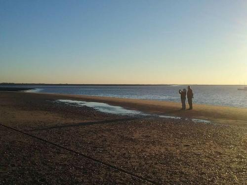 two people standing on a beach near the water at The Patch at Snettisham Beach in Snettisham