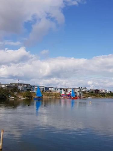 a large body of water with blue sailboats on it at The Patch at Snettisham Beach in Snettisham