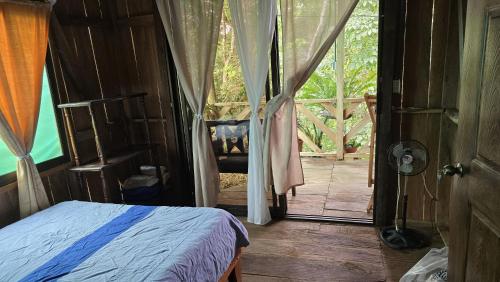 a bedroom with a bed and a door to a porch at Landscape-Cabaña Summer-Full Equipada in La Cruz