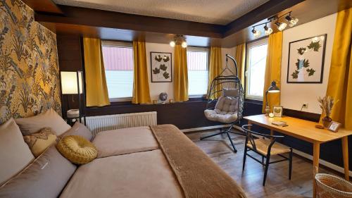 a living room with a couch and a desk at Yellow Lounge Schwarzwald - mit Veranda in Winzeln