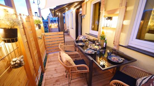 a porch with a table and chairs on a balcony at Yellow Lounge Schwarzwald - mit Veranda in Winzeln
