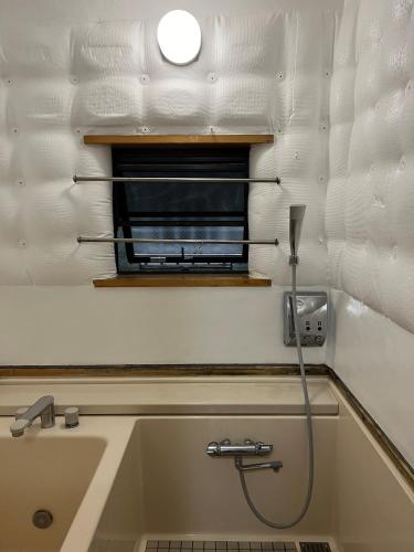 a bathroom with a bath tub with a shower at Ikebukuro sta. 10mins walk. Rough style 88㎡ House in Tokyo