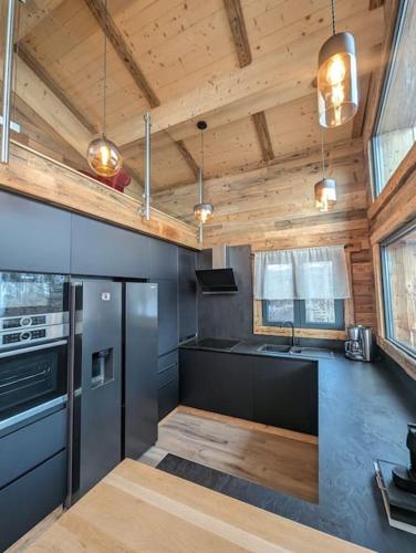 Il comprend une cuisine équipée d'un réfrigérateur et d'une cuisinière. dans l'établissement Luxueux chalet montagnard, à Isola 2000