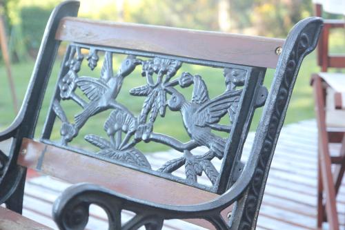 a metal bench with birds on the back of it at Hostería Antu Kuyen in San Carlos de Bariloche