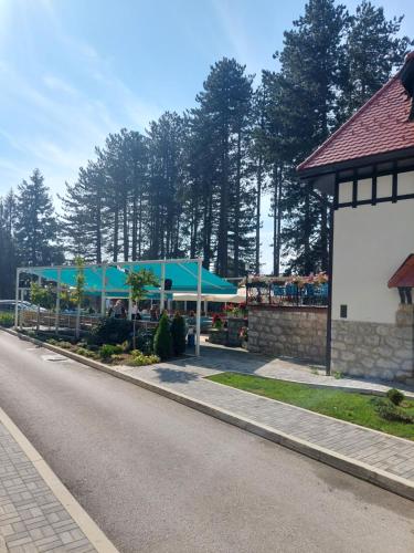 a street with a building with blue umbrellas on it at Titova Vila Apartman Jelka in Palisad
