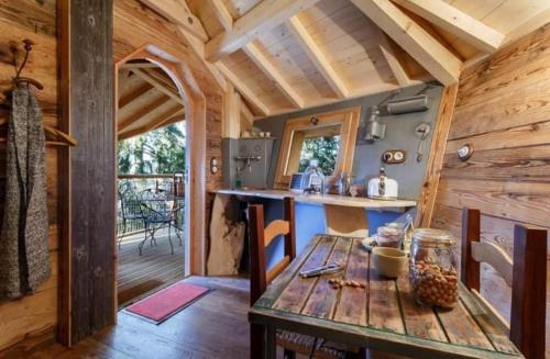 a wooden kitchen with a wooden table in a cabin at Cabanes Chartreuse insolite - Cabane "La Bordée" in Saint-Pierre-de-Chartreuse