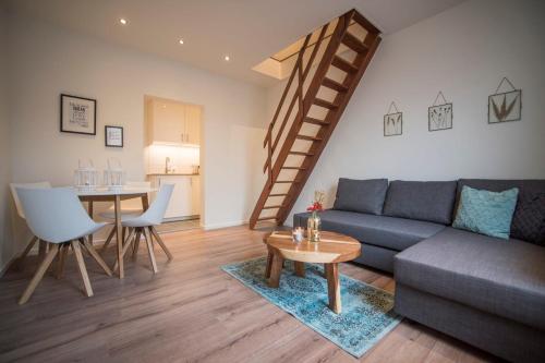 una sala de estar con un sofá y una mesa en Apartment Zandster, en Zandvoort