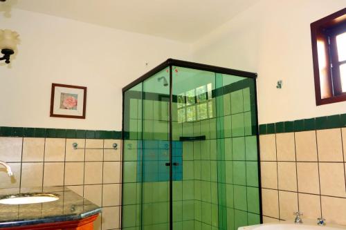 a glass shower in a bathroom with a sink at Brazish Pousada in Paraty