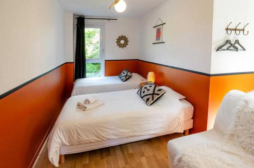 two beds in a room with orange and white walls at Elegant 2 bedroom triplex with parking Honfleur in Honfleur