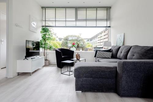 een woonkamer met een bank en een tv bij Sea Shell apartment in Zandvoort