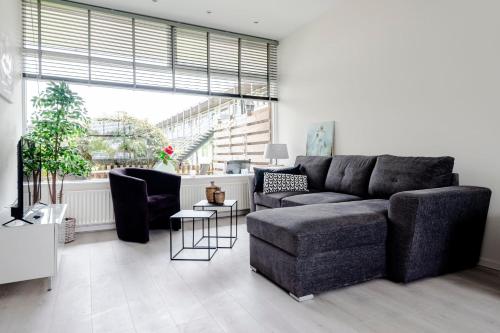 een woonkamer met een bank en een stoel bij Sea Shell apartment in Zandvoort