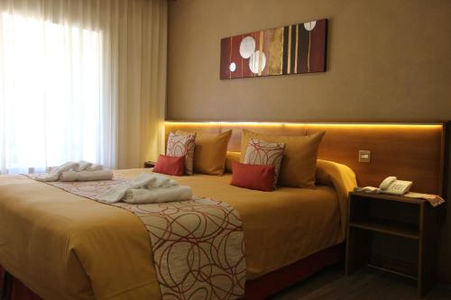 a hotel room with a bed with towels on it at Hostería Antu Kuyen in San Carlos de Bariloche