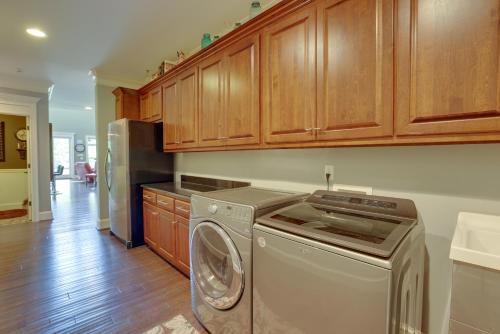 a kitchen with a washing machine and wooden cabinets at Fish, Swim and More Lakefront Alabaster Home in Alabaster