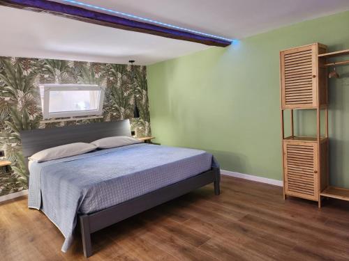 una camera da letto con un letto e una TV a parete di L'angolo dei sogni a Palermo