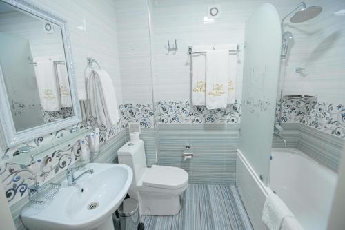 a bathroom with a sink and a toilet and a tub at Gur Emir Palace boutique hotel in Samarkand