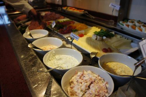 una línea de buffet con tazones de comida en un mostrador en Hotel Am Hopfenmarkt, en Rostock
