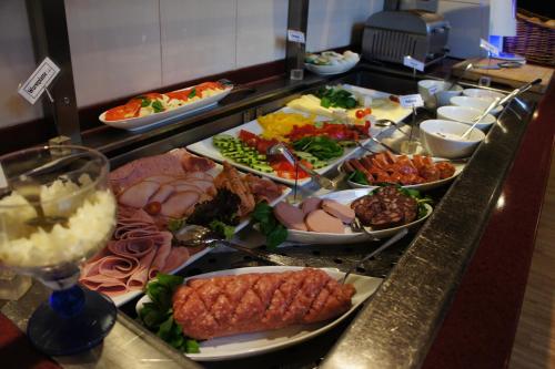 Una línea de buffet con muchos tipos diferentes de comida. en Hotel Am Hopfenmarkt, en Rostock