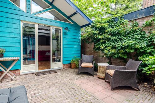 a patio with chairs and a blue house at Ocho in Zandvoort
