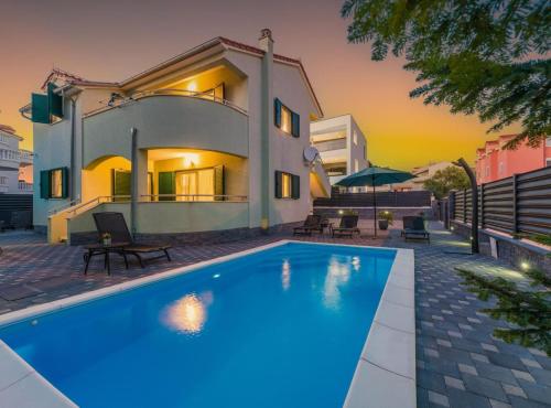 a villa with a swimming pool in front of a house at Villa S in Vodice