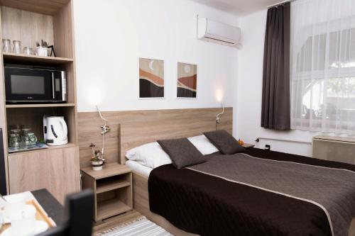 une chambre avec un grand lit et une télévision dans l'établissement Marika Vendégháza, à Tokaj