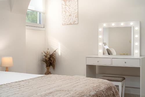 a bedroom with a bed and a dresser and a mirror at Villa Rosa 3 Bedroom with Sea View in Tragaki