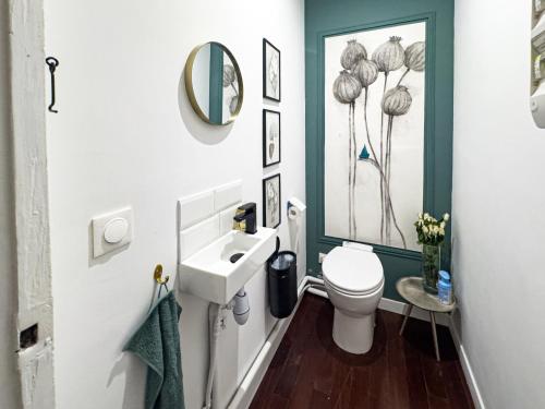 une salle de bain avec un lavabo, des toilettes et un miroir dans l'établissement PenBed-2BR- Lovely parisian apt near Bastille, à Paris