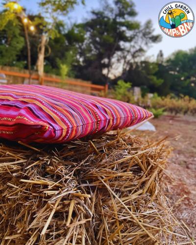 a red blanket sitting on top of a pile of hay at Chill Garden Experience B&B in San Pietro in Bevagna