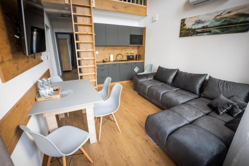 a living room with a couch and a table at Bobrowe Wzgórza Resort in Jelenia Góra