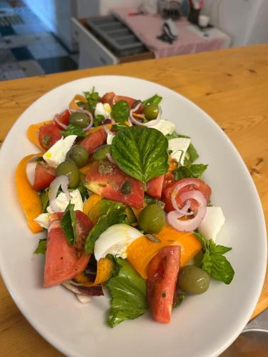 a white plate with a salad on a table at Hotel la Maggioressa in Ischia