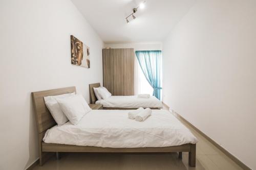 a bedroom with two beds and a window at Spacious 2 bedroom apartment in Cospicua
