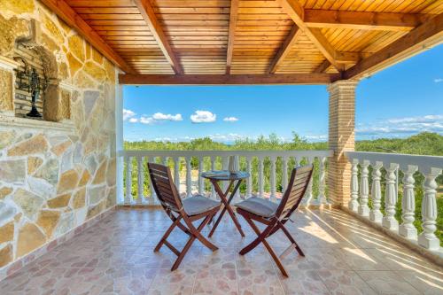 a patio with two chairs and a table on a balcony at Villa Rosa 3 Bedroom with Sea View in Tragaki