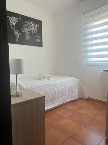 a bedroom with a bed with a table and a window at Ensino 22 in Ourense