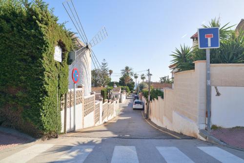 an empty street with a fence and a car on the road at ARCoIRIS in Málaga