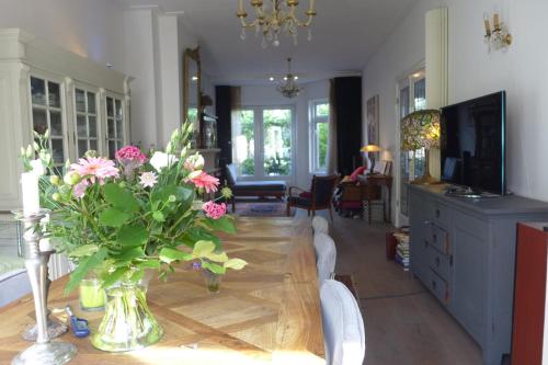 a vase of flowers on a table in a living room at Family Home Marie in Zandvoort