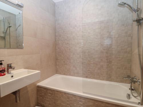 Un baño con bañera, lavabo y ducha. en 7 Warren Edge Close, en Bournemouth