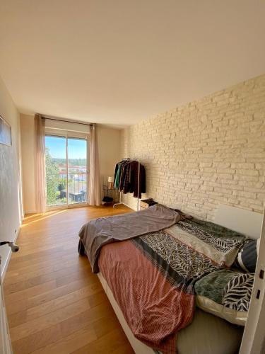 une chambre avec un lit et un mur de briques dans l'établissement Appartement de 80m2 dans la forêt de Tanchet, à Les Sables-dʼOlonne