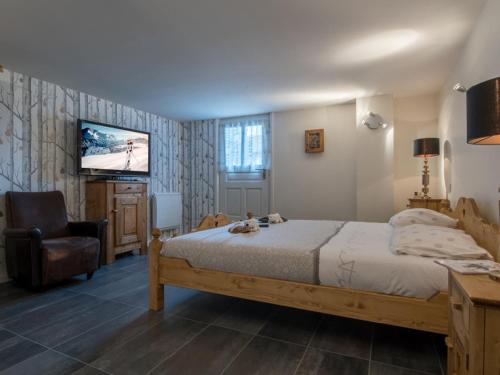 a bedroom with a bed and a chair and a television at Triplex moderne avec terrasse à Courchevel 1850, près des pistes et services, 3 suites, parking - FR-1-575-145 in Courchevel