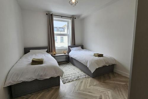 two beds in a room with a window at Camden Market Properties in London
