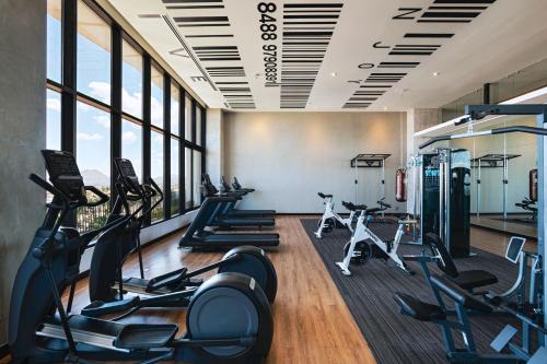 a gym with treadmills and ellipticals in a room with windows at Vetta, Distrito Uno, Autograph Collection in Chihuahua