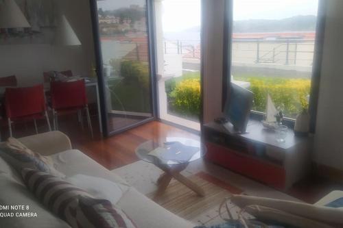 a living room with a couch and a tv on a table at Edificio Tudor un mirador al Cantábrico in Comillas